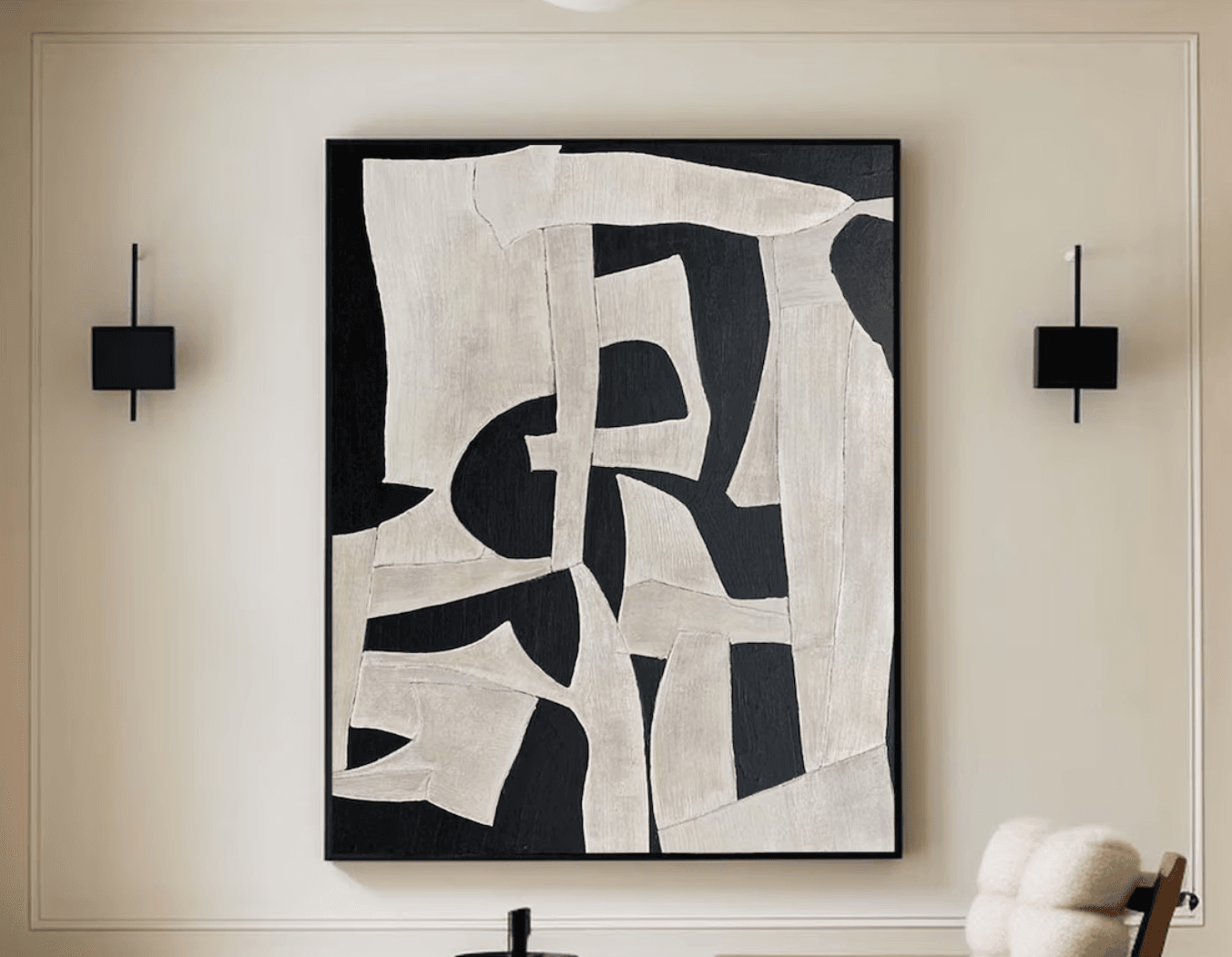 Bold black and white wall art idea for bedroom with two black wall sconces hanging on either side of the artwork