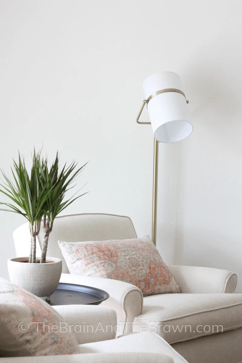 Antique pillow in a cream chair in the corner of a family room