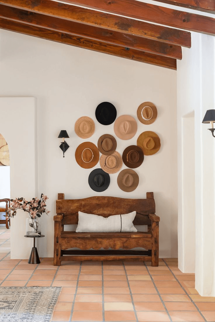 An entryway with a wooden bench and hats hanging above 