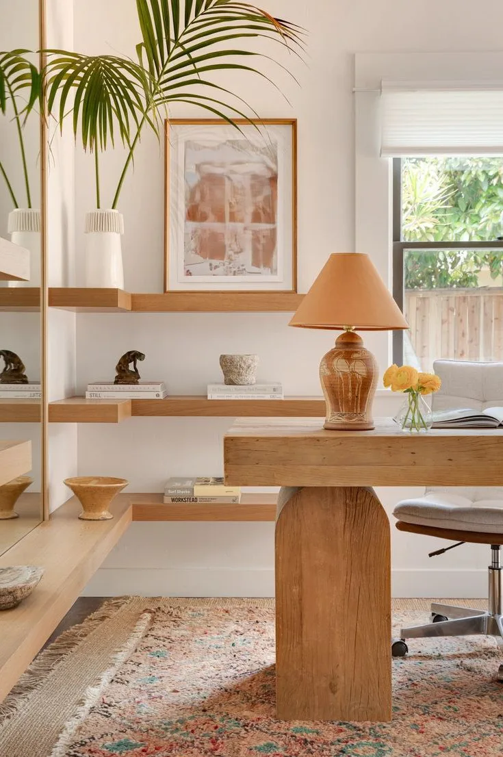 a light and bright home office with modern curved wood desk in natural wood