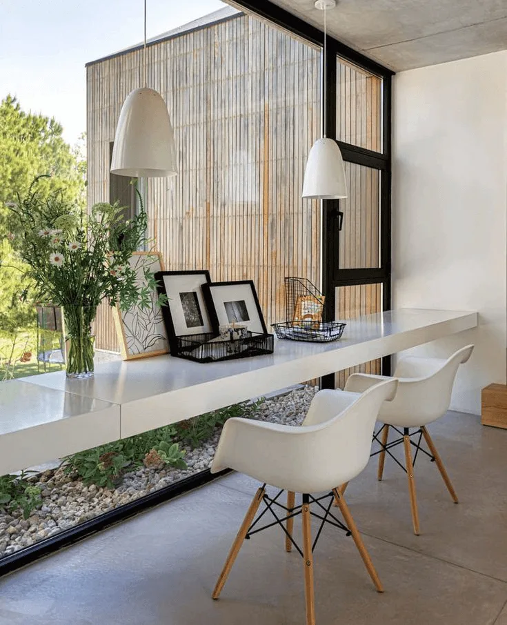 modern floating desk in front of windows in a home office with concrete floors