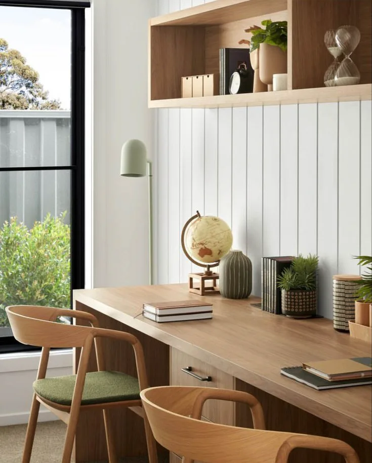 a home office with two modern chairs and plank walls in white, wood desk and wood floating shelf above