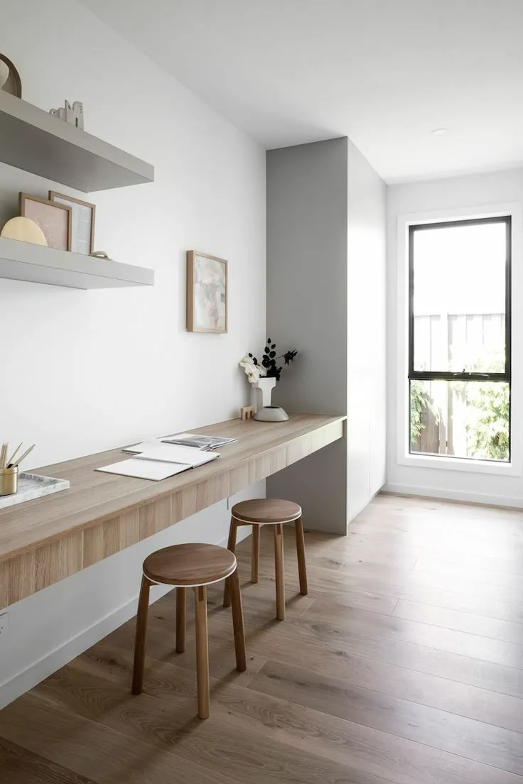 a simple white and wood home office design with stools and a floating wood desk
