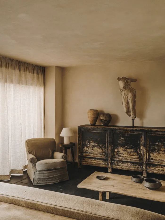 spanish-style home interior living room with antique black sideboard buffet and sculptural elements
