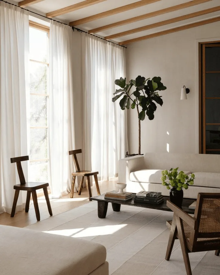 a modern living room with sculptural chairs and wood ceiling beams, large floor to ceiling windows