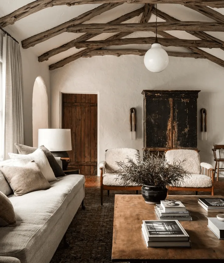 a hacienda-style living room with wood beams, wood door, and Spanish-style decor