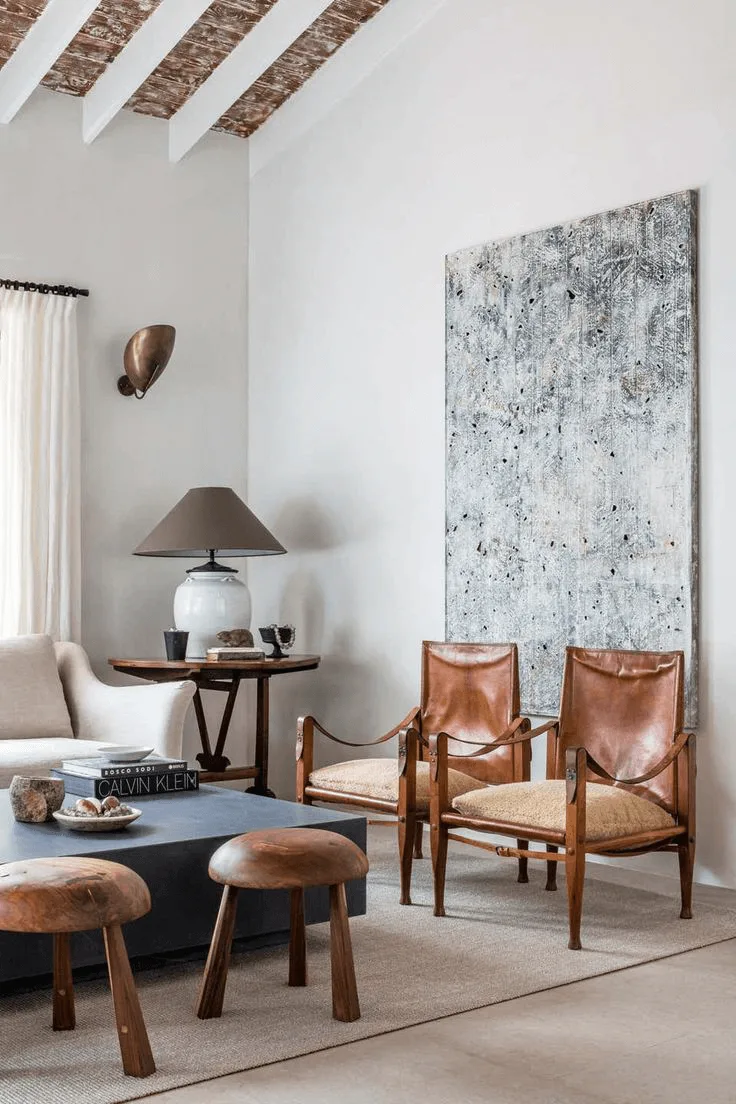 a living room with large scale artwork and leather chairs