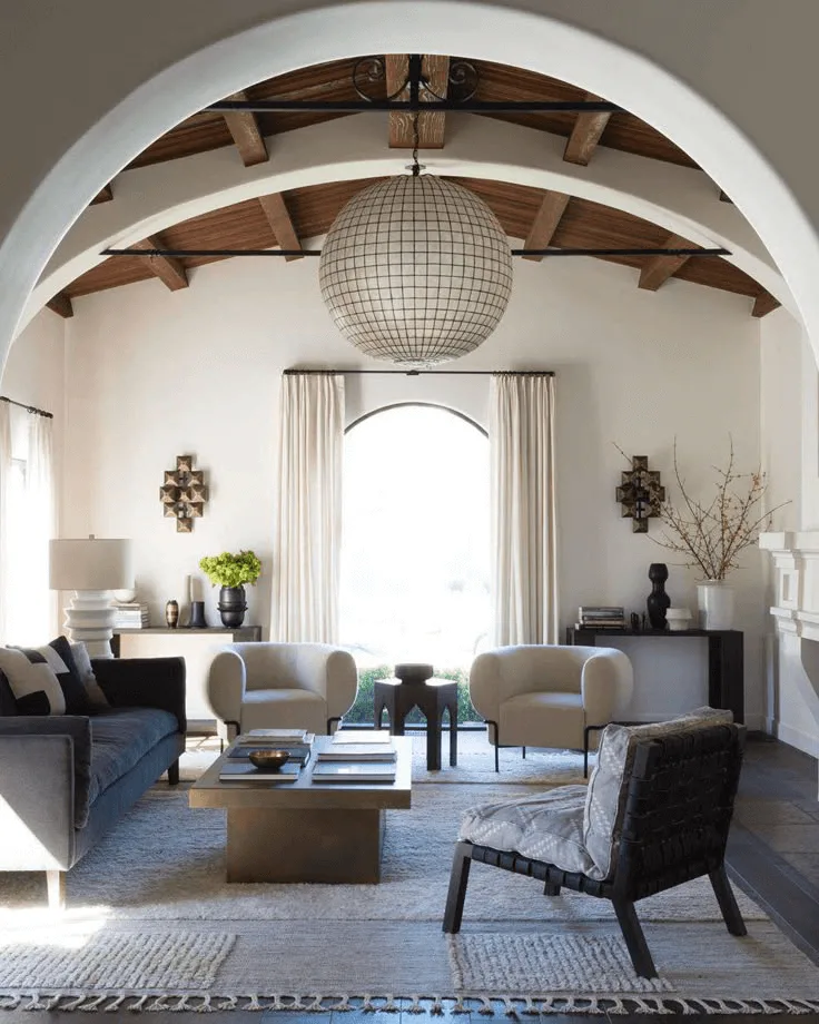 a Spanish-style home interior design of living room with large ceiling light and arches on arched ceiling
