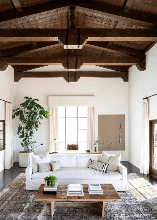 Spanish-style living room with wood ceiling and white furniture, wood accents