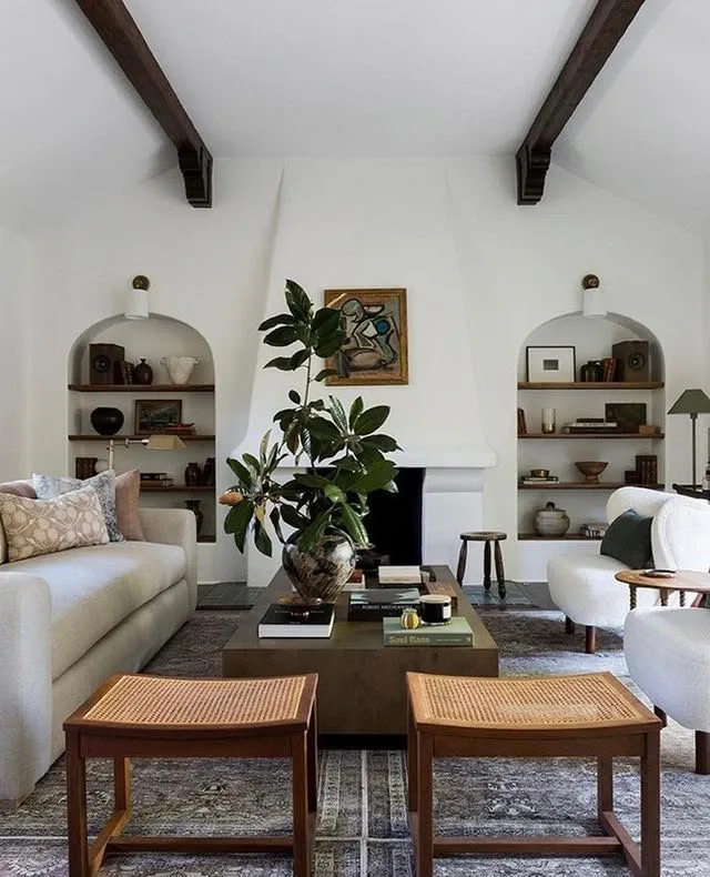 a home interior in Spanish style, living room with white plaster fireplace and wood ceiling beams