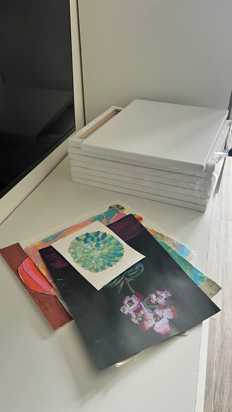 a white surface with cluttered art and canvases on it