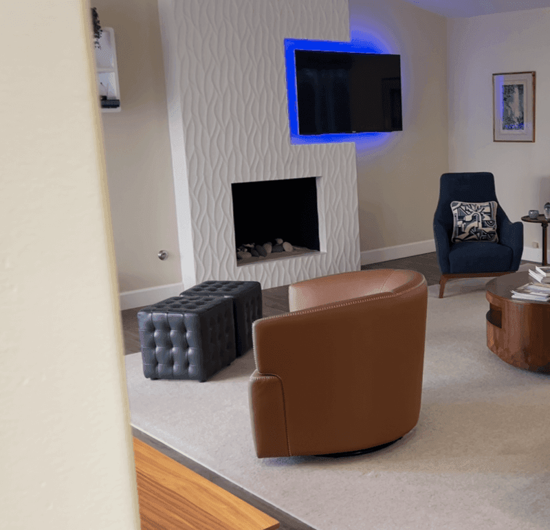 a white tile fireplace with TV in a neutral living room
