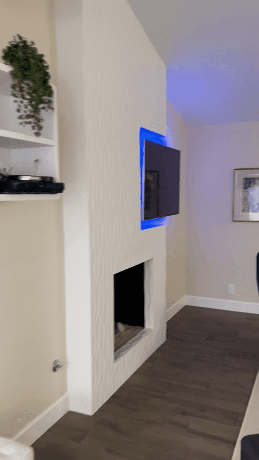 a before and after of a white tile fireplace with TV in a white and beige neutral living room