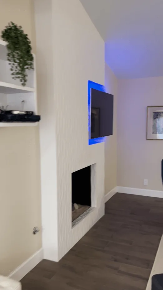 a before and after of a white tile fireplace with TV in a white and beige neutral living room