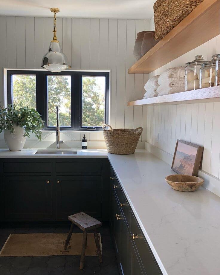 a small dark black and white laundry room in L-shape layout 