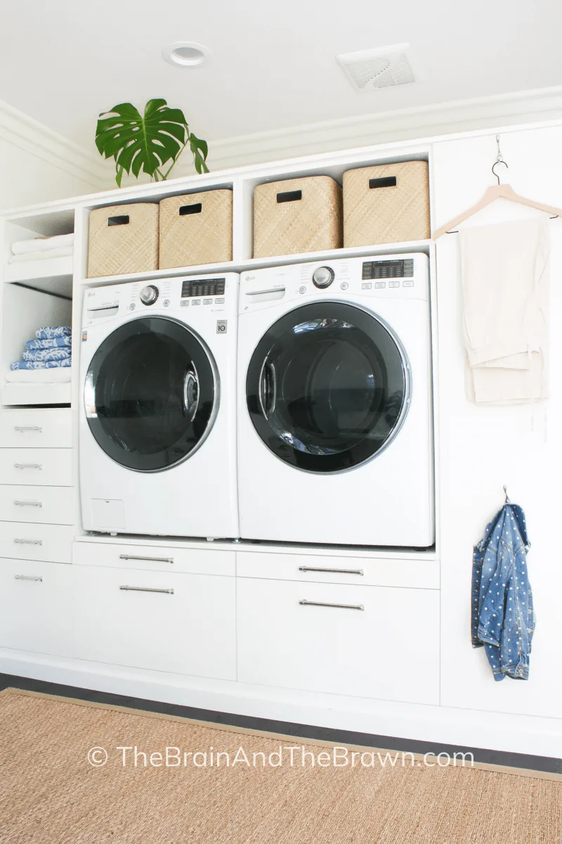 a small laundry room wall cabinet with drawers and basket shelves
