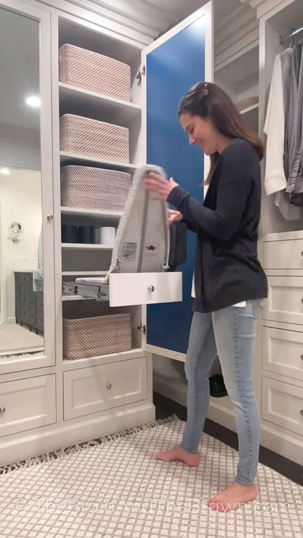 a woman using a pull-out folding drawer ironing board for laundry 