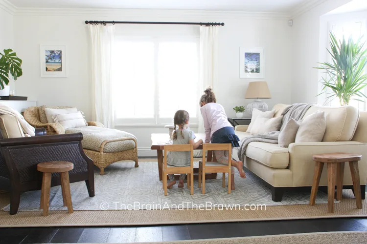 a small living room arrangement with sofa, chaise, and chairs with a puzzle area