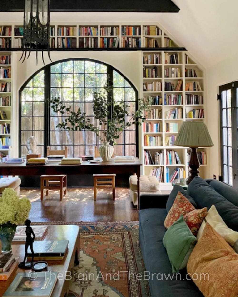 a home interior design showing angled bookshelves and living room with dining room