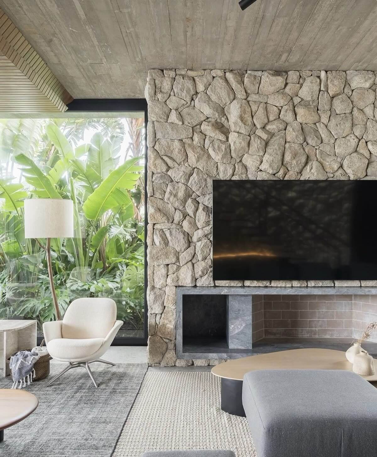 natural stone fireplace in living room tropical setting with modern furniture and stone surround