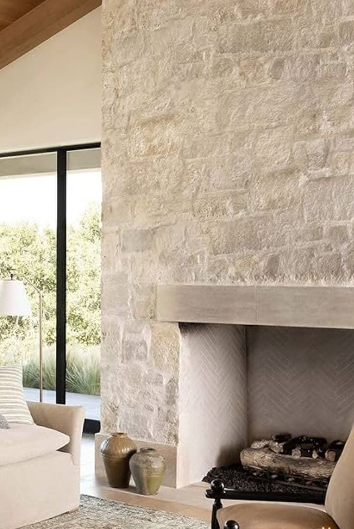 a natural stone fireplace in a living room with herringbone tile interior