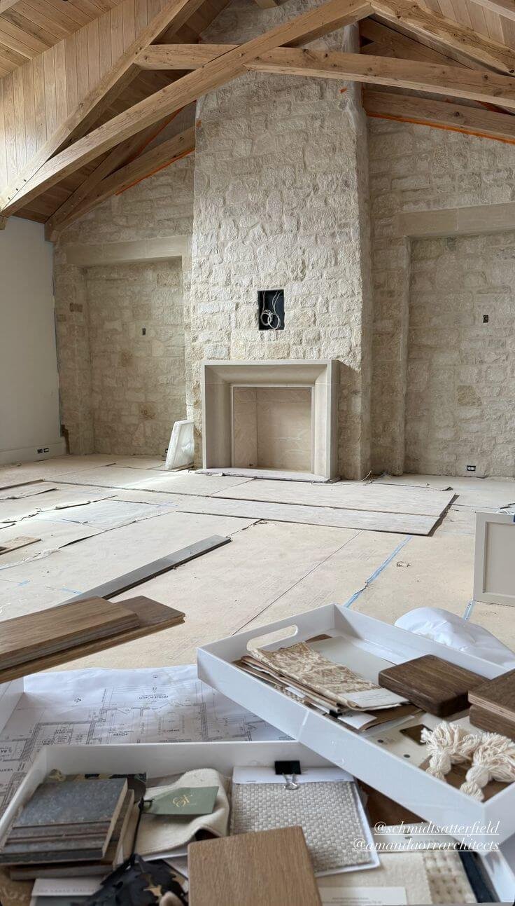 a living room with floor-to-ceiling stone veneer including a large stone fireplace with stone surround and mantel