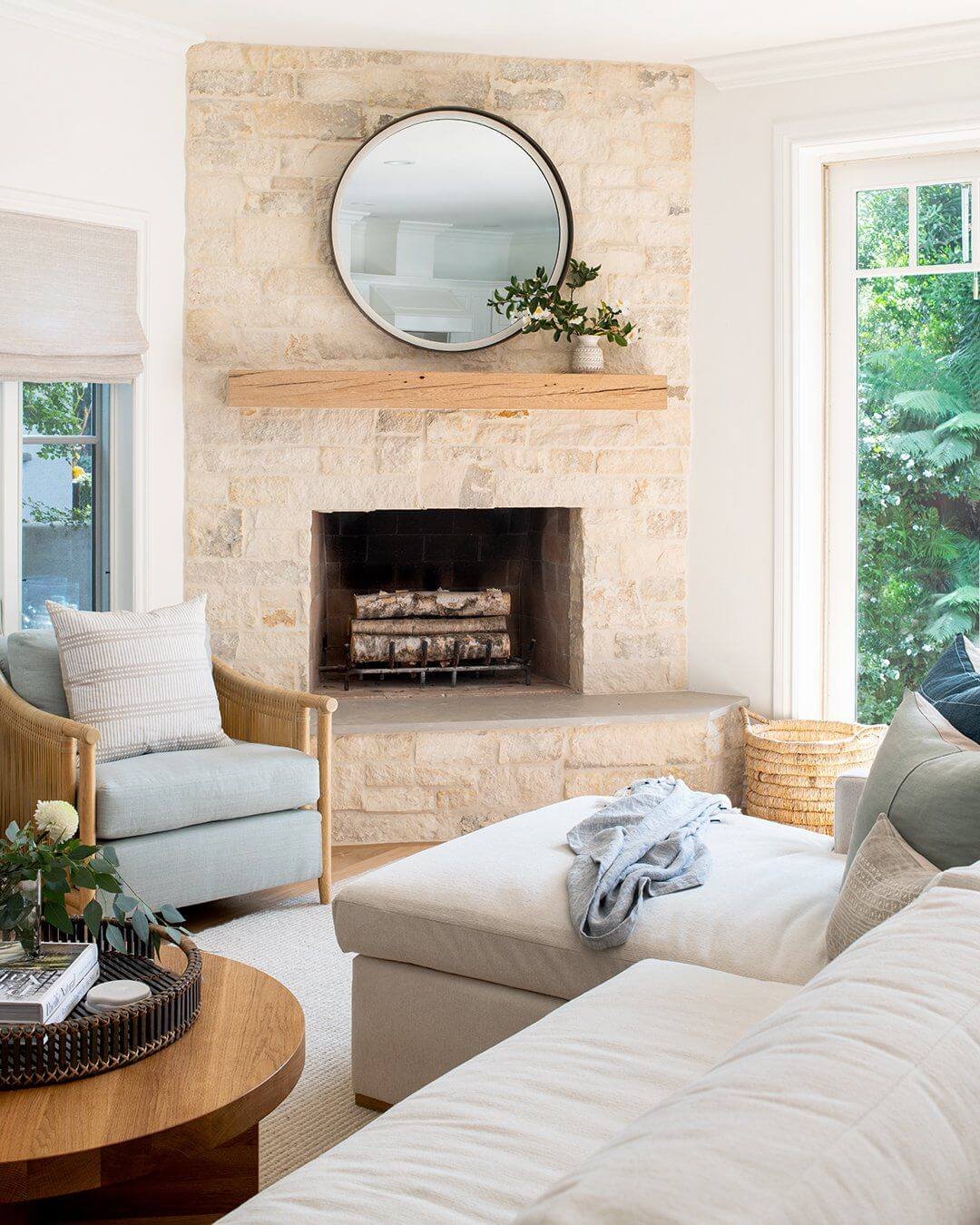 a corner fireplace made of stone with a wood mantel 
