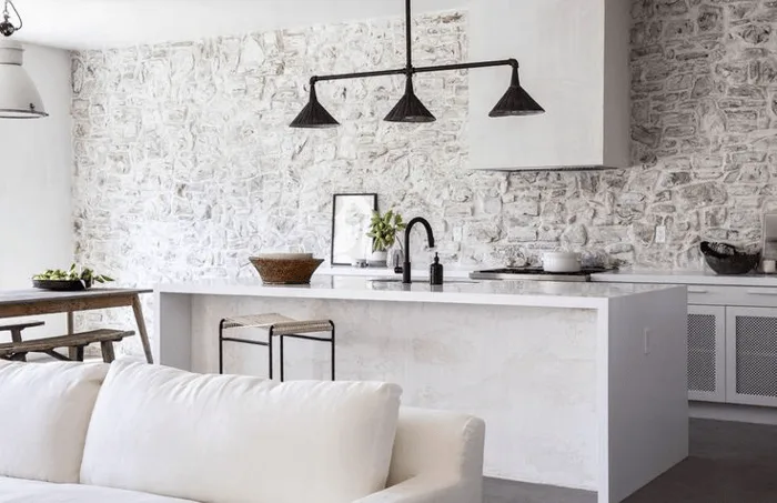 A neutral stone kitchen backsplash with whites and blacks and creams 
